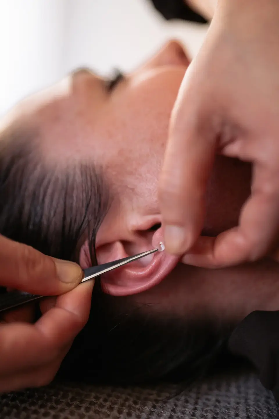 Close-up of an instrument touching the outer ear at manualtherapies, Frederiksberg.