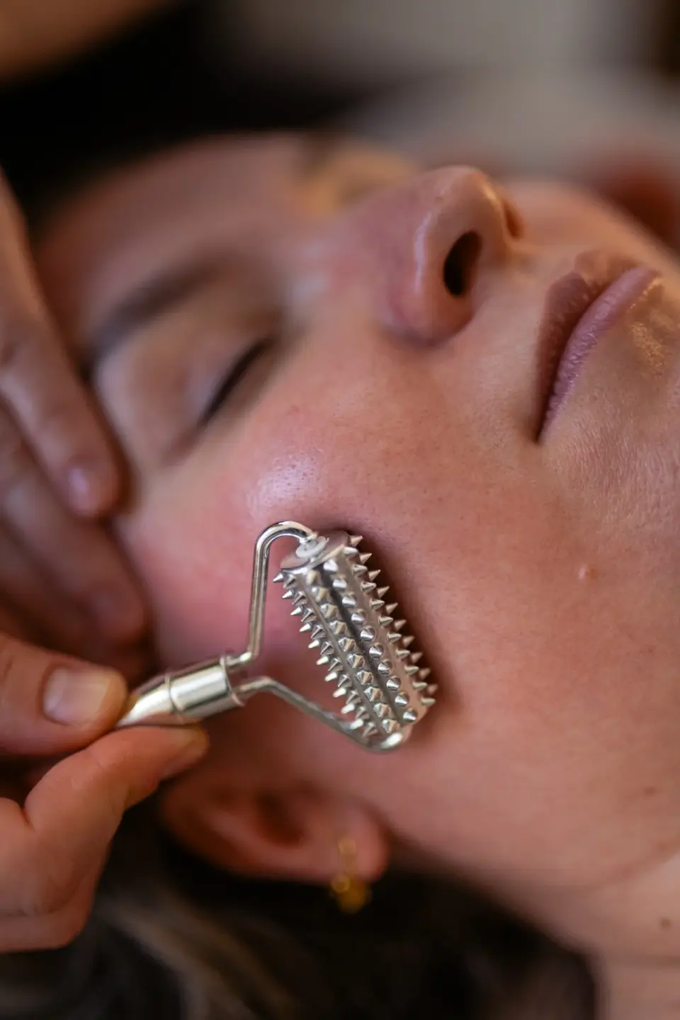 Metalowy wałeczek przesuwany po policzku — manualtherapies, Frederiksberg.